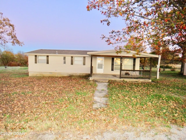 ranch-style house with a lawn and covered porch