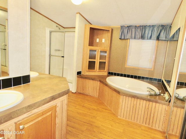 bathroom featuring vanity, wood-type flooring, crown molding, and independent shower and bath