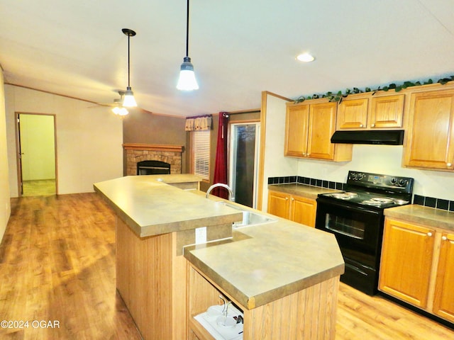 kitchen featuring light wood-type flooring, an island with sink, and black range with electric cooktop