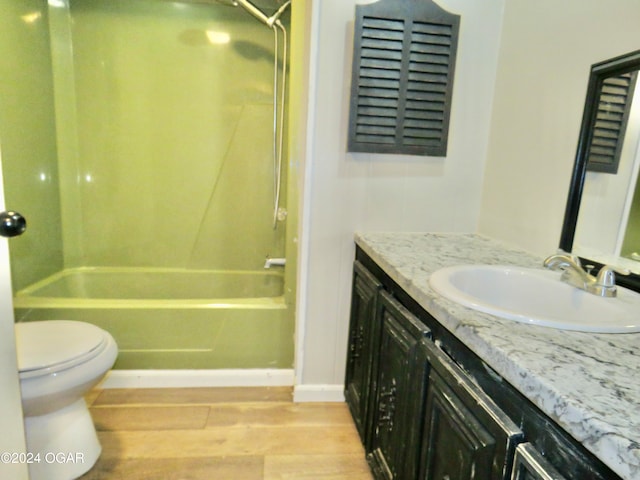 full bathroom with vanity, toilet, wood-type flooring, and bathtub / shower combination