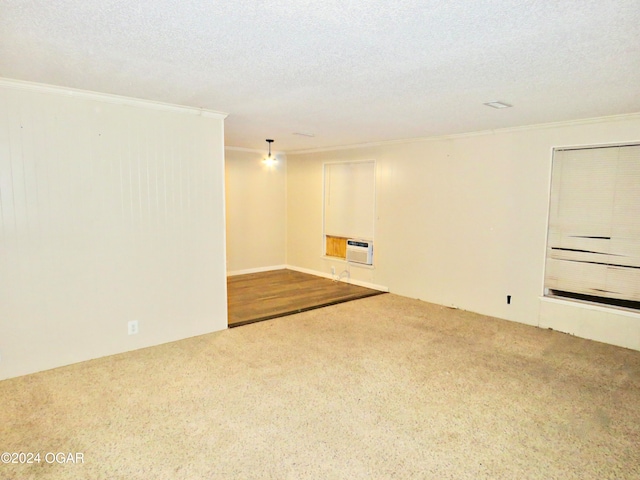 carpeted empty room featuring ornamental molding, a textured ceiling, and heating unit