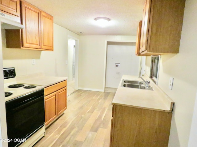 kitchen with a textured ceiling, light wood-type flooring, white range with electric stovetop, and sink