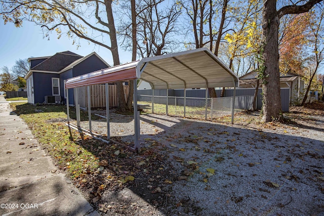 view of property exterior with a carport, a storage unit, and central AC unit