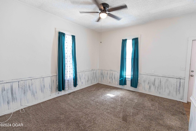 unfurnished room with carpet flooring, ceiling fan, and a textured ceiling