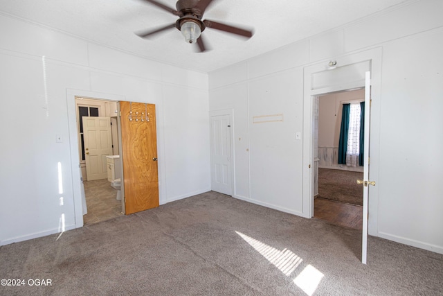 unfurnished bedroom featuring ceiling fan, carpet floors, and ensuite bathroom