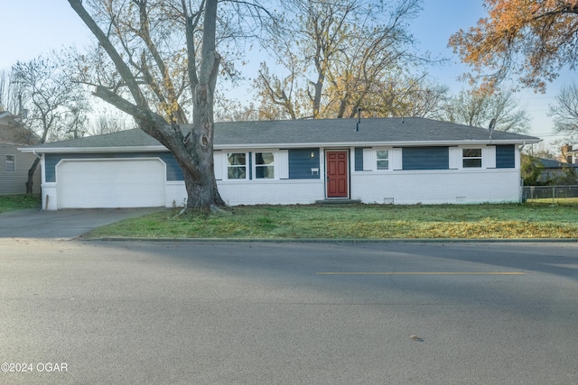 ranch-style house featuring a garage and a front yard