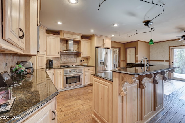 5623 Rivercrest Valley Dr, Joplin, MO 64804 - kitchen featuring appliances with stainless steel finishes, wall chimney range hood, light wood-style flooring, a kitchen breakfast bar, and ornamental molding