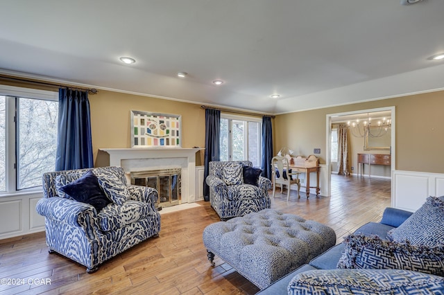 5623 Rivercrest Valley Dr, Joplin, MO 64804 - living area featuring ornamental molding, a chandelier, wood finished floors, a fireplace with flush hearth, and a wainscoted wall