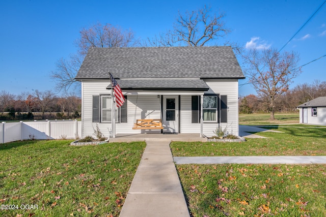 bungalow-style house featuring covered porch and a front yard