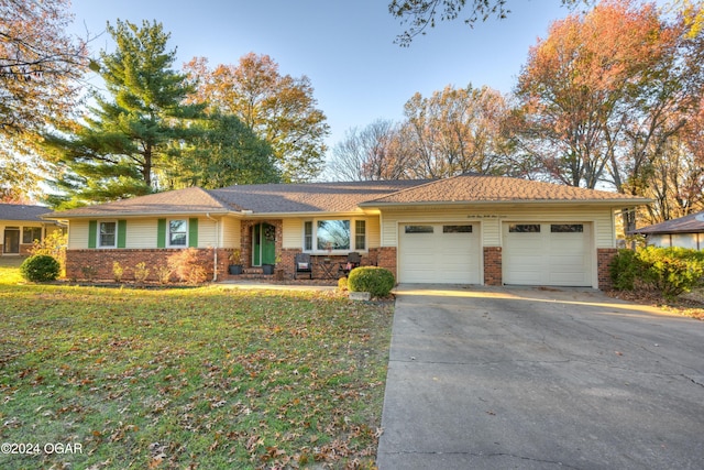 ranch-style home featuring a front lawn and a garage