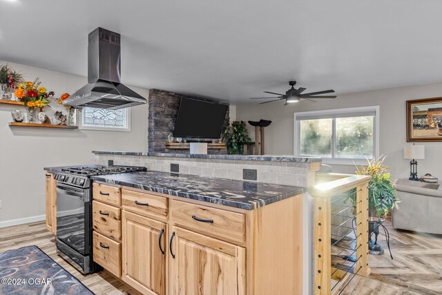 kitchen featuring range with gas cooktop, light brown cabinetry, island range hood, ceiling fan, and light parquet floors