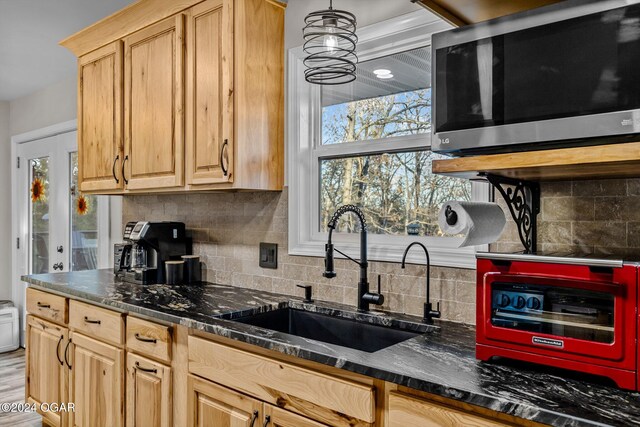 kitchen with decorative backsplash, sink, light brown cabinets, and dark stone counters