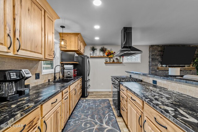 kitchen featuring hanging light fixtures, backsplash, a healthy amount of sunlight, island range hood, and gas stove