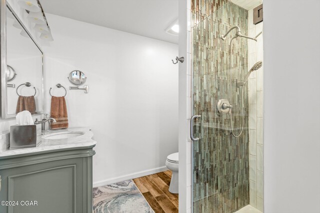 bathroom featuring vanity, walk in shower, hardwood / wood-style floors, and toilet