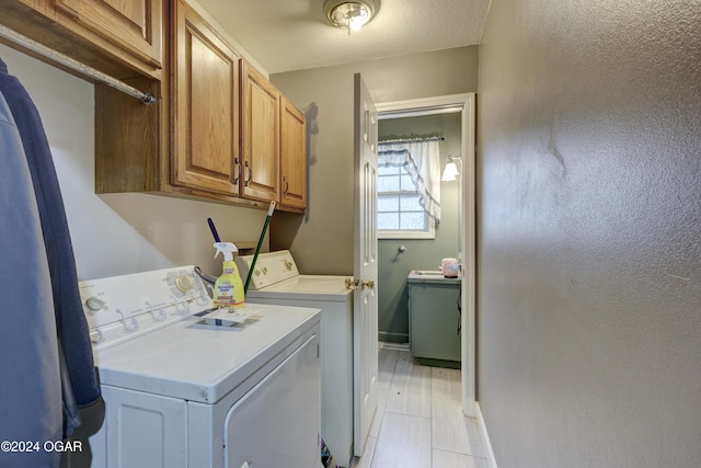 laundry room with separate washer and dryer, light tile patterned floors, and cabinets