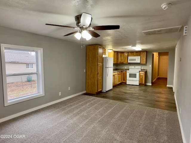 kitchen with a textured ceiling, ceiling fan, dark hardwood / wood-style flooring, and white appliances