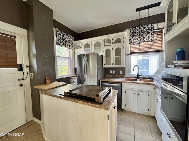 kitchen featuring a wealth of natural light, white cabinets, pendant lighting, and appliances with stainless steel finishes