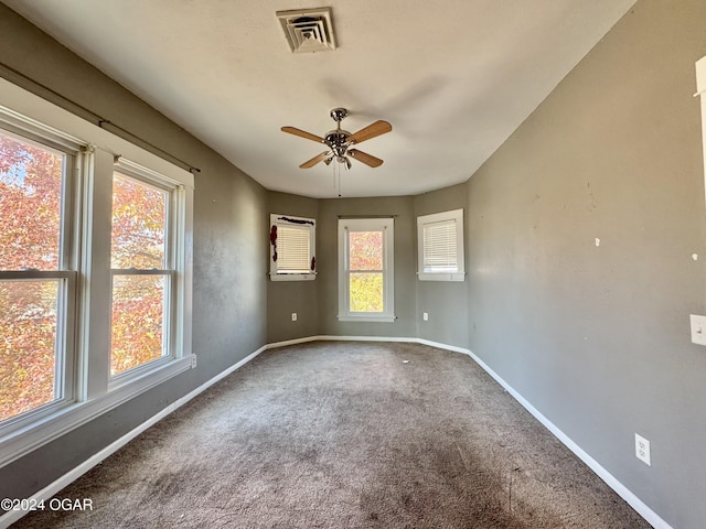 carpeted spare room featuring ceiling fan