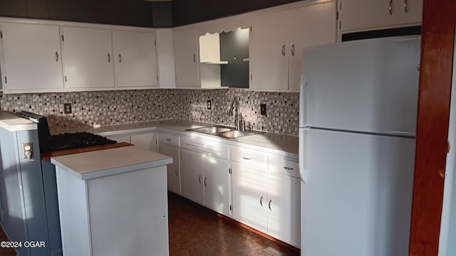 kitchen featuring decorative backsplash, white fridge, white cabinetry, and sink