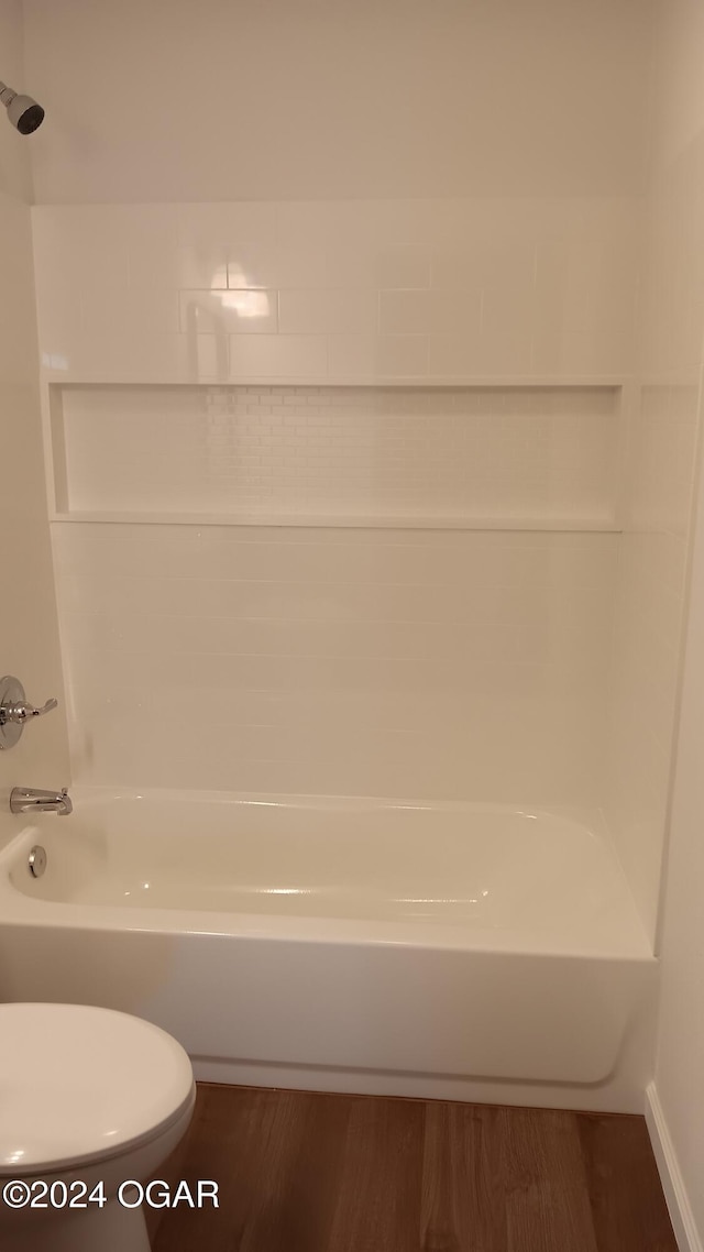 bathroom featuring bathtub / shower combination, hardwood / wood-style floors, and toilet