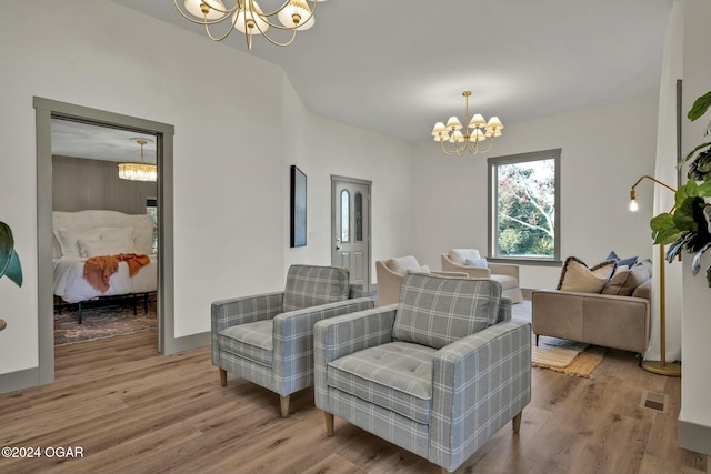 living area with hardwood / wood-style floors and an inviting chandelier