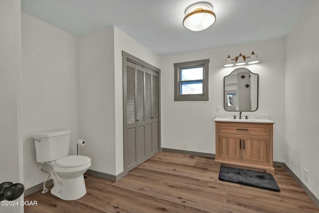 bathroom with hardwood / wood-style floors, vanity, and toilet