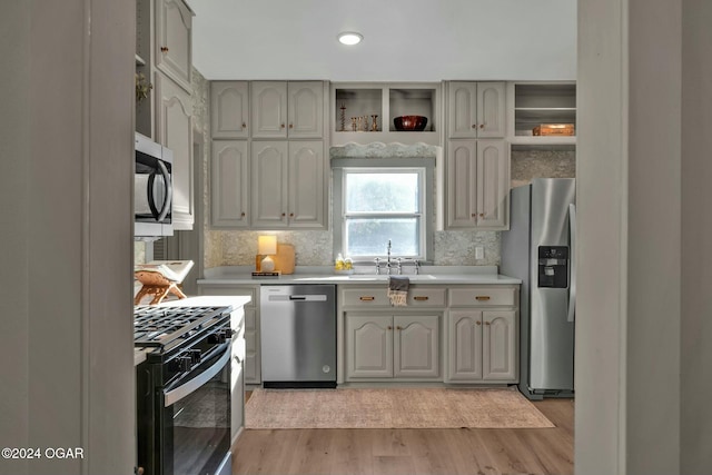 kitchen featuring gray cabinets, sink, stainless steel appliances, and light hardwood / wood-style flooring