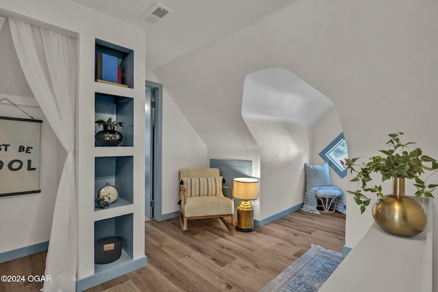 living area featuring built in features and hardwood / wood-style flooring