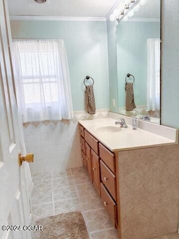 bathroom with tile patterned floors, crown molding, and vanity