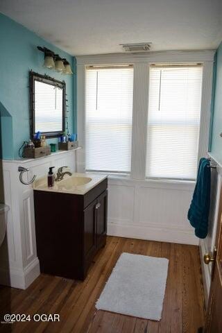 bathroom featuring vanity, hardwood / wood-style flooring, toilet, and plenty of natural light