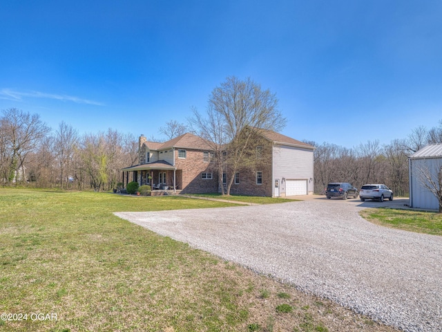 view of front of property with a garage, covered porch, and a front lawn