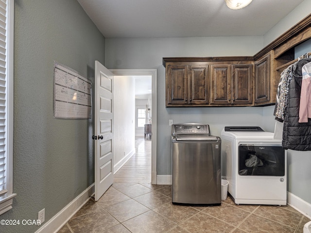 washroom featuring light tile patterned flooring, cabinets, and separate washer and dryer