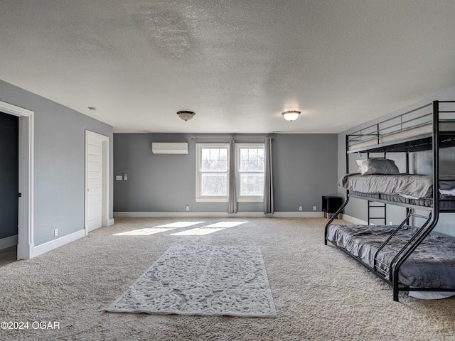 carpeted bedroom with an AC wall unit and a textured ceiling