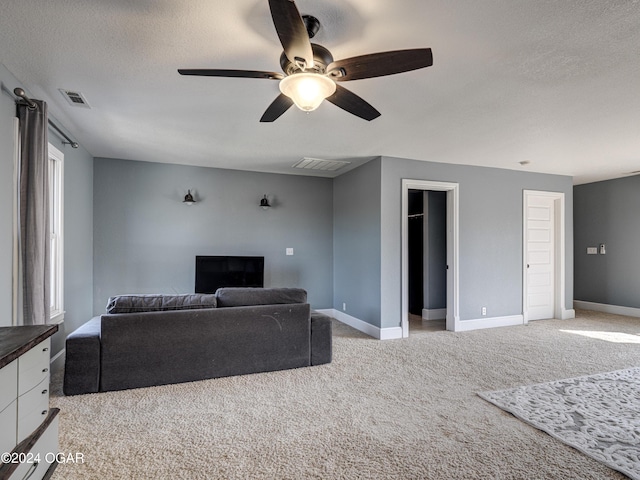 living room featuring a textured ceiling, ceiling fan, and light carpet