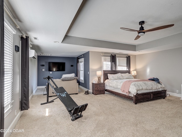 bedroom featuring ceiling fan, light colored carpet, and a wall mounted AC