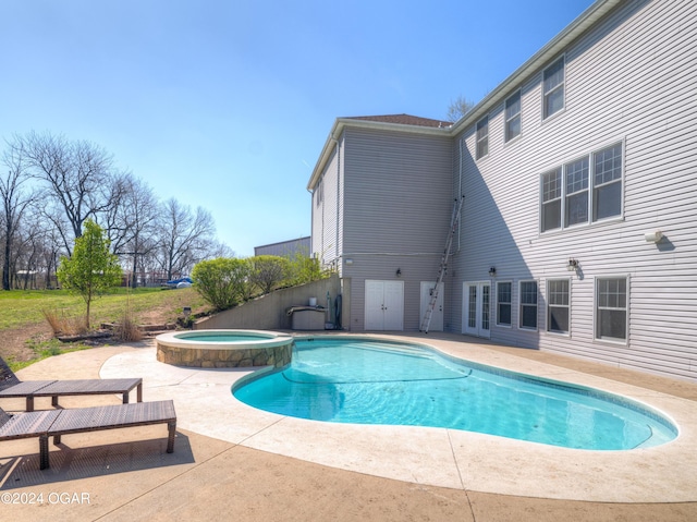 view of pool with an in ground hot tub and a patio