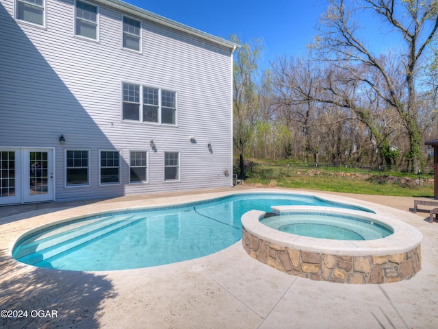 view of swimming pool featuring an in ground hot tub and a patio