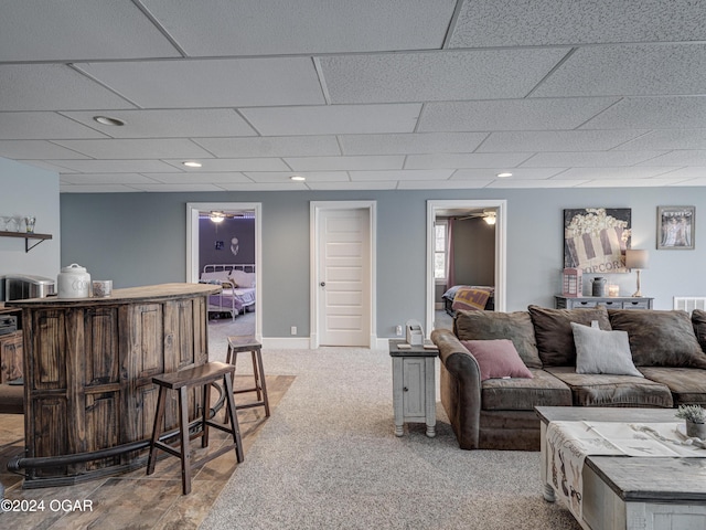 carpeted living room with a paneled ceiling