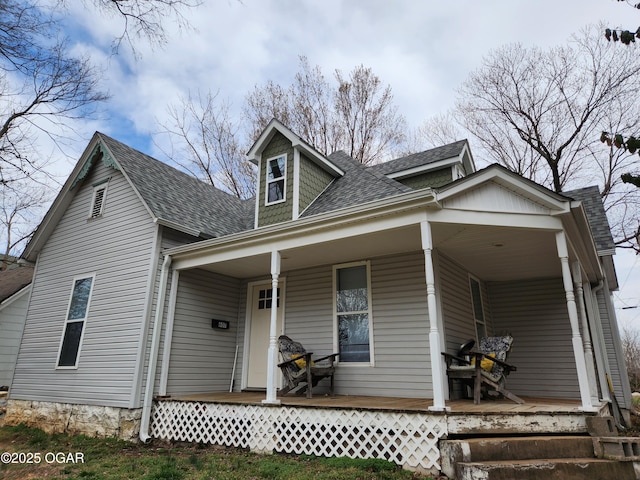 view of front of home featuring covered porch and a shingled roof