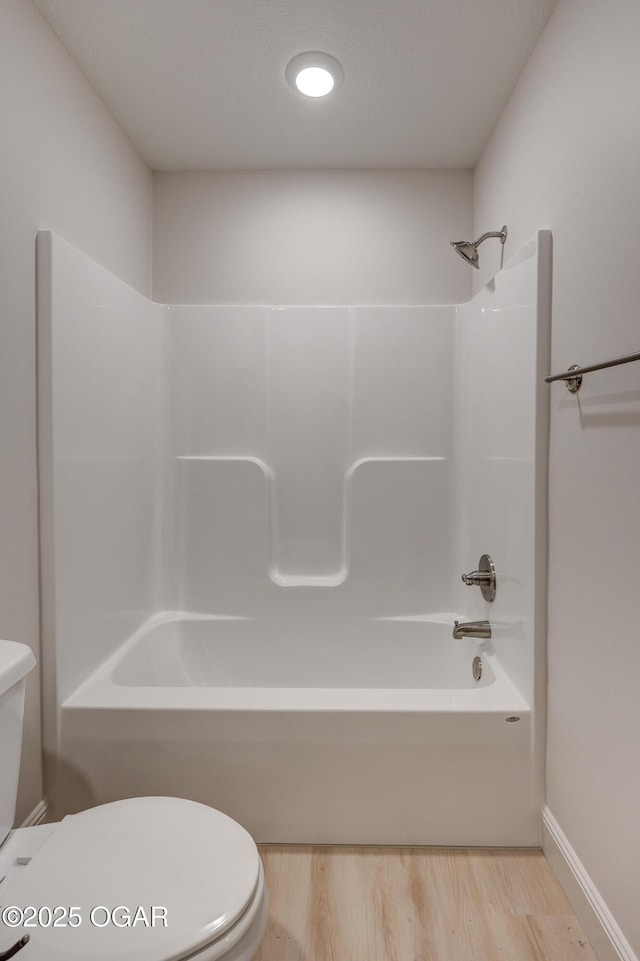 bathroom with hardwood / wood-style flooring, toilet, and shower / tub combination