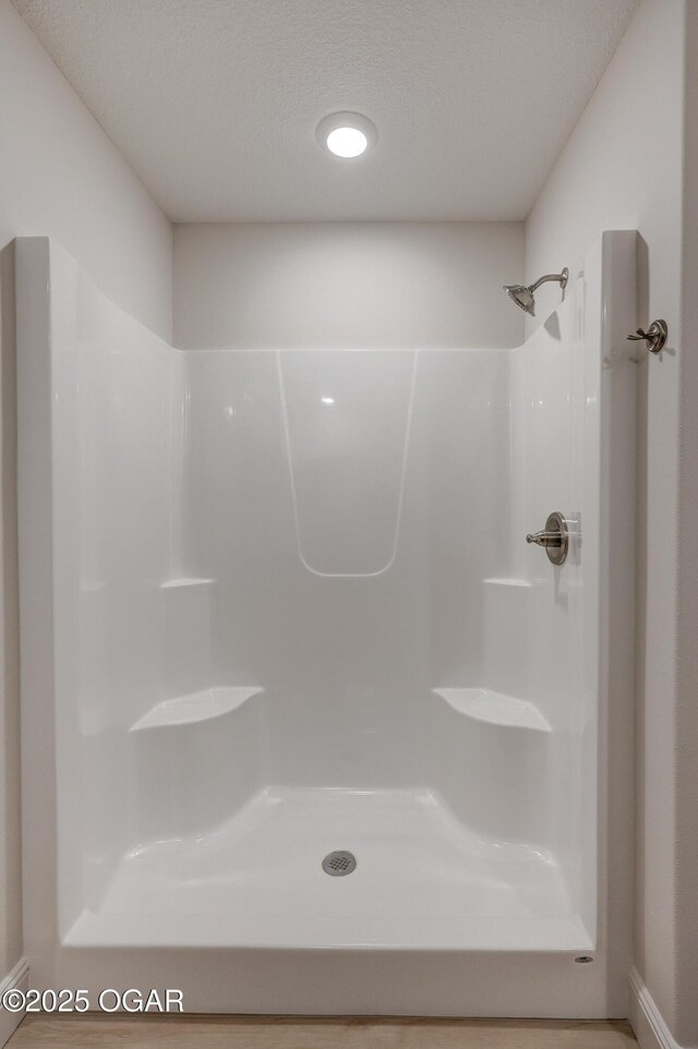 bathroom with a textured ceiling and walk in shower