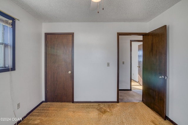 unfurnished bedroom featuring light carpet and a textured ceiling