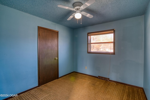 empty room featuring carpet flooring, a textured ceiling, and ceiling fan