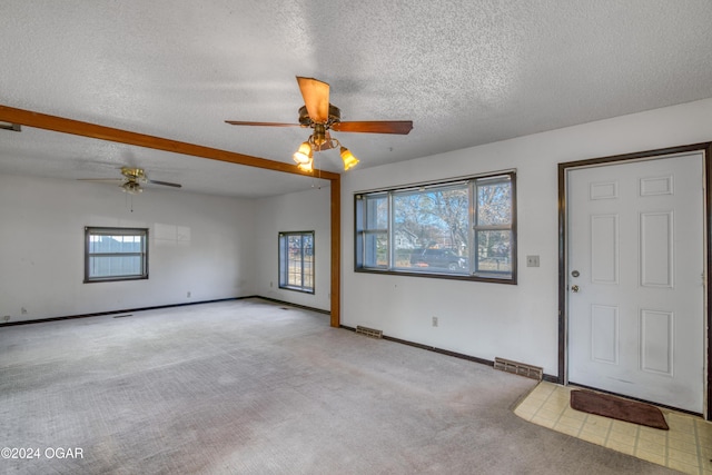 interior space with ceiling fan and a textured ceiling