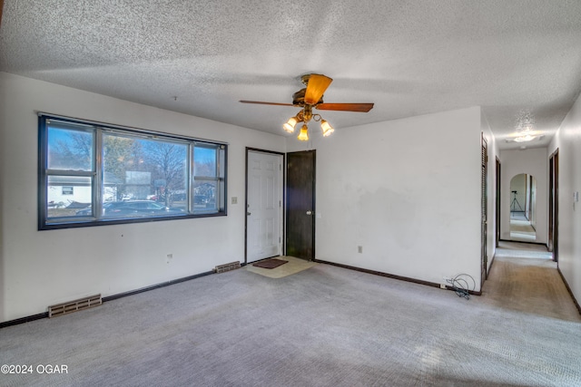 carpeted spare room with ceiling fan and a textured ceiling