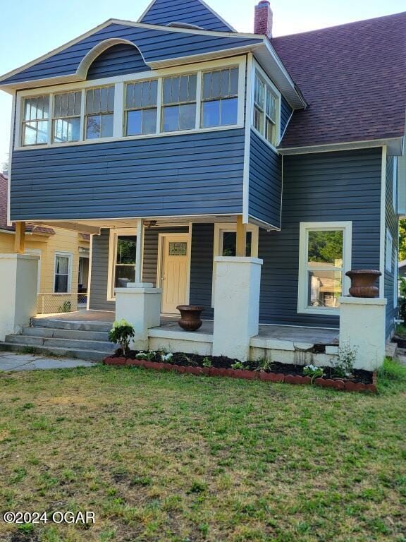 view of front of home featuring covered porch and a front yard