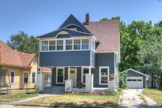 view of front facade featuring covered porch, a garage, and an outdoor structure