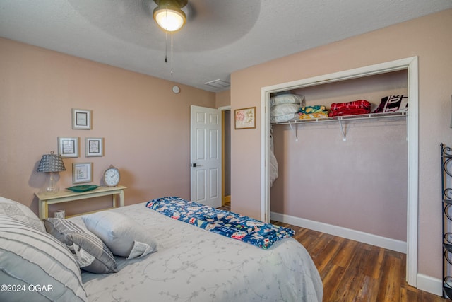 bedroom featuring a textured ceiling, ceiling fan, a closet, and dark hardwood / wood-style floors