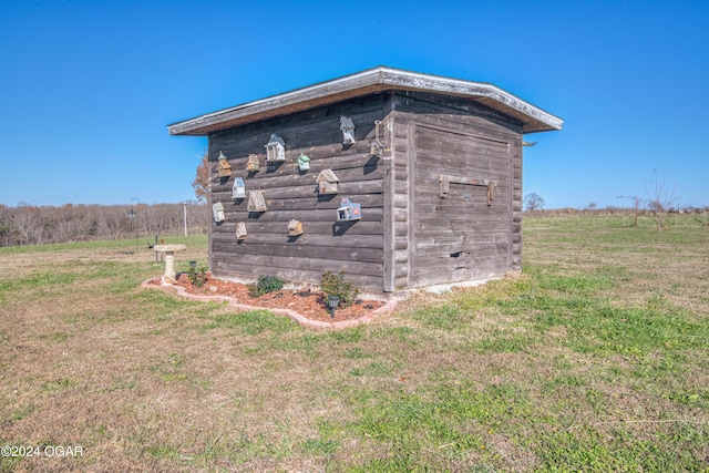 view of outdoor structure featuring a lawn and a rural view