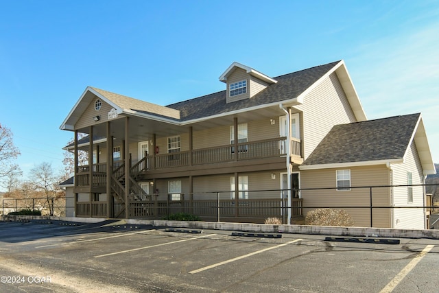 exterior space with stairs, uncovered parking, and fence